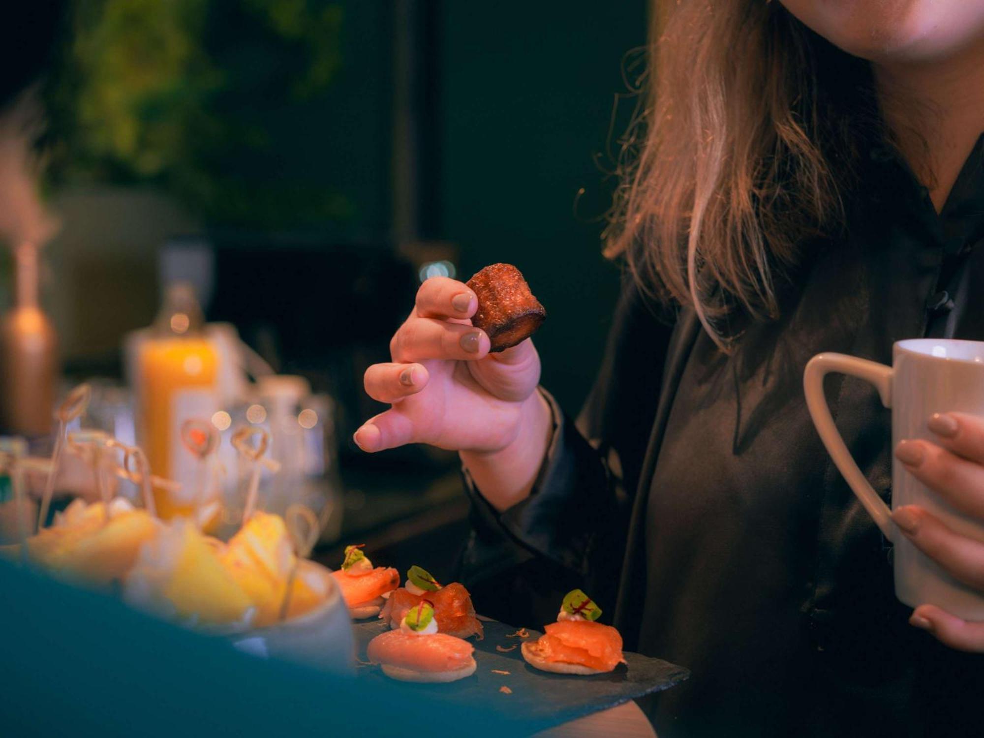 Nest Paris La Defense - Mgallery Puteaux Ngoại thất bức ảnh A woman holding a piece of sushi